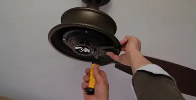 Electrician installing ceiling fan mounting bracket and fixture in Bloomington, IN