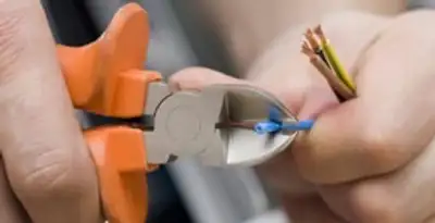 professional electrical services showing precise wire cutting by licensed electricians in Bloomington, IN