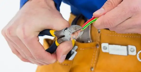 licensed electrician securing electrical wiring with professional tools during service work in Bloomington, IN