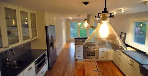 Residential electrician installing modern indoor light fixture in a home in Bloomington, IN