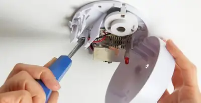 Certified technician wiring smoke detector during installation in Bloomington, IN